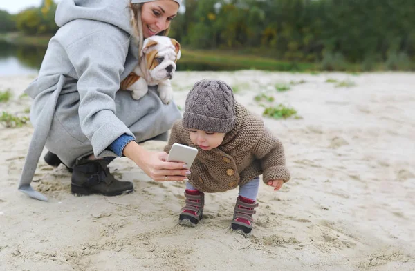 Mutlu anne ve bebek kız açık havada selfie yapma köpek ile