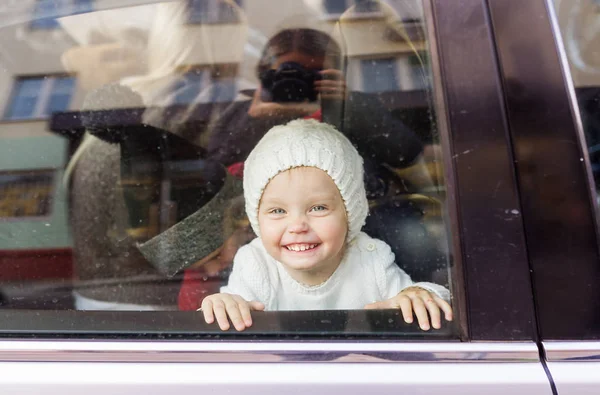 Feliz niña primer plano retrato a través del vidrio de la ventana del coche —  Fotos de Stock