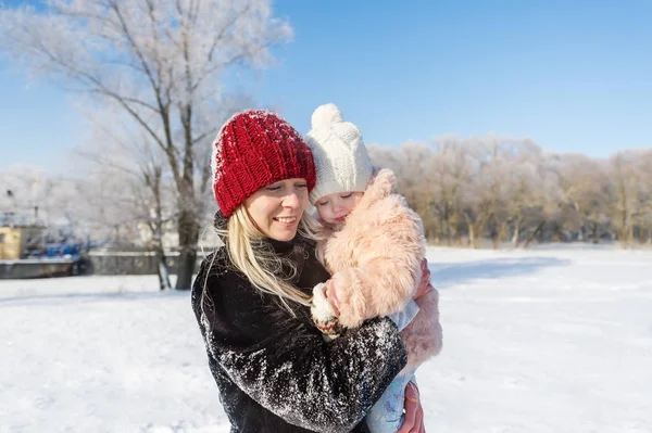 Mãe feliz e bebê no parque de inverno. família ao ar livre. mamãe alegre com seu filho — Fotografia de Stock