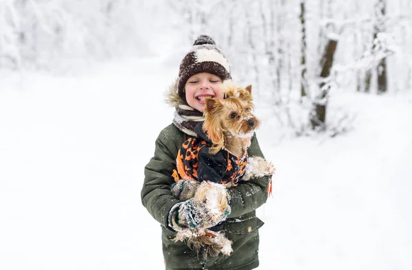 Kleiner Junge und kleiner Hund im Winterpark. — Stockfoto