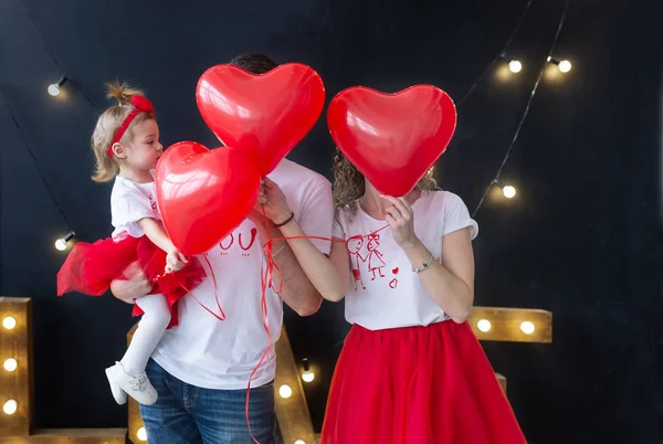 Junge schöne Eltern mit kleinen Mädchen spielen, Ferienballons. Valentinstag — Stockfoto