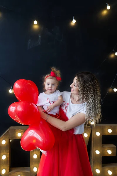 Une mère et un bébé merveilleux entourés de ballons en forme de cœur — Photo