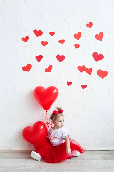 Charmant gosse au coeur rouge. Bonne petite fille avec ballon rouge à un mur de briques vierges. Mariage, concept Valentin — Photo