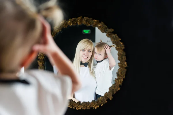 Reflexión en un espejo de la madre y su hijita — Foto de Stock