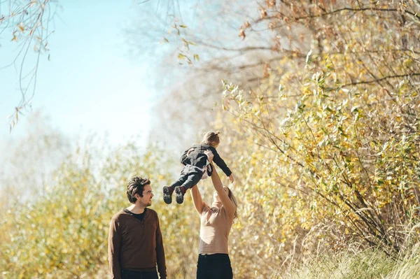 Familia feliz. Joven madre vomita bebé en el cielo, en el soleado día de otoño . — Foto de Stock