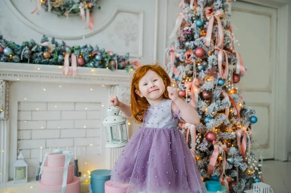 Una linda pelirroja vestida de violeta sostiene un candelabro . — Foto de Stock