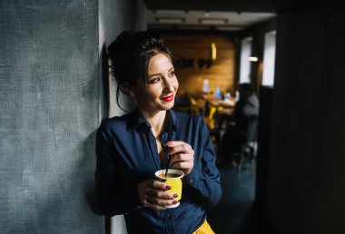 Kafede dinlenirken bir fincan kahveyle şık bir esmer.