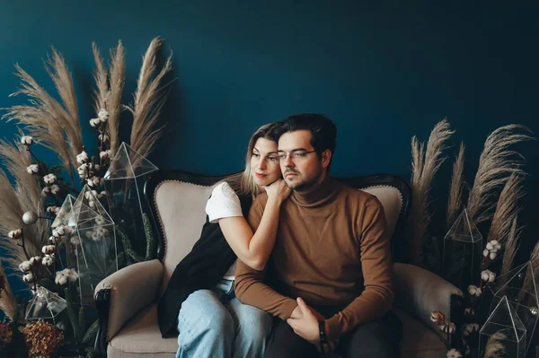 Joven hombre y mujer abrazándose en un cómodo sillón en casa . —  Fotos de Stock
