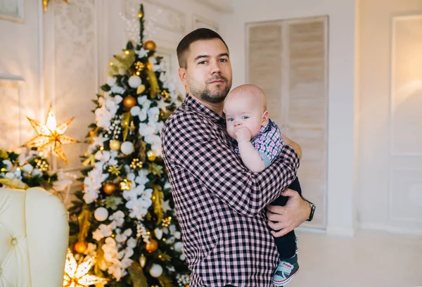 Padre está con un pequeño hijo delante del árbol de Navidad . — Foto de Stock