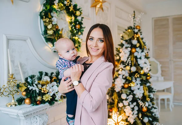 Madre de familia e hijo pequeño posa en casa en las vacaciones de Navidad. Las fiestas de Año Nuevo . — Foto de Stock