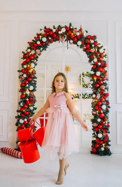 Sonriente chica sonriente en vestido festivo con cajas de regalo rojas . — Foto de Stock
