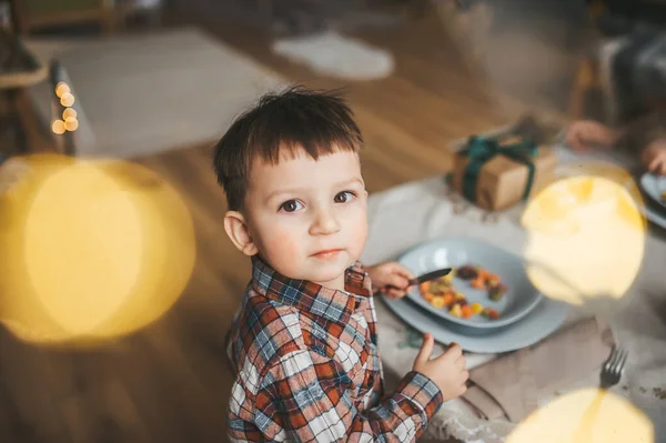 Dwuletni chłopiec z talerzem smacznej pasty w kuchni. Zbliżenie — Zdjęcie stockowe