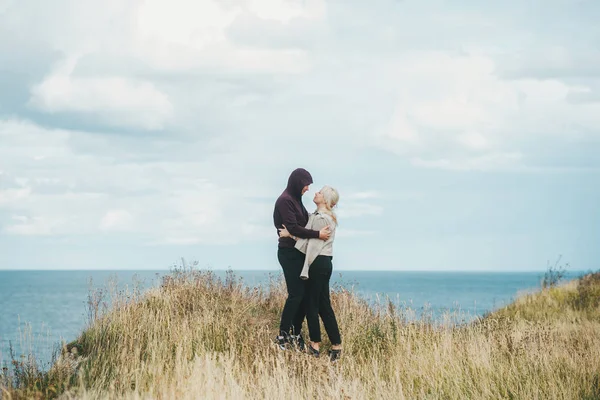 Romantic view of couple when they embrace on the edge of the rocky coast of the Baltic sea. — Stock Photo, Image