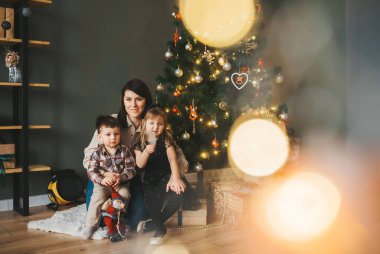 Kış akşamında mutlu bir aile Noel kutlaması odasında Noel ağacı ve hediyelerle.