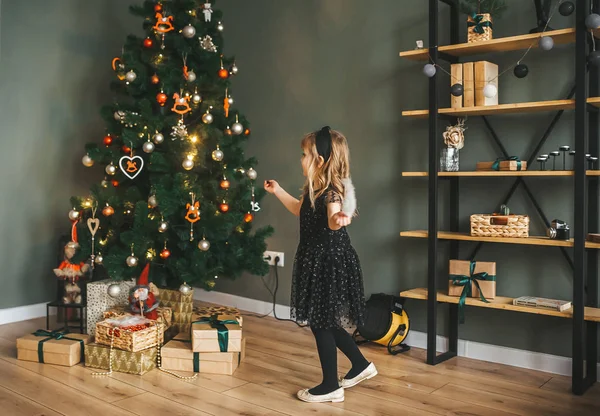 Una niña divirtiéndose en la sala de fiestas cerca del árbol de Navidad — Foto de Stock