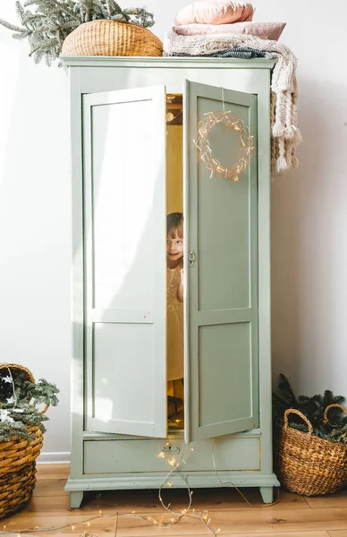 Маленька дівчинка ховається всередині білого шафи . — стокове фото