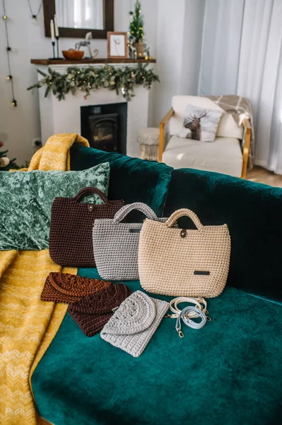 Conjunto de bolsos femeninos multicolores de punto con bandas de pecho están en un sofá en la habitación . — Foto de Stock