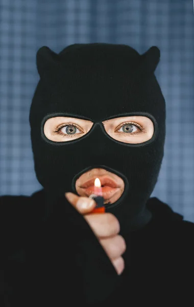 Muzułmańska terrorystka trzymająca zapalniczkę przed ustami. Skupienie selektywne w oczach — Zdjęcie stockowe