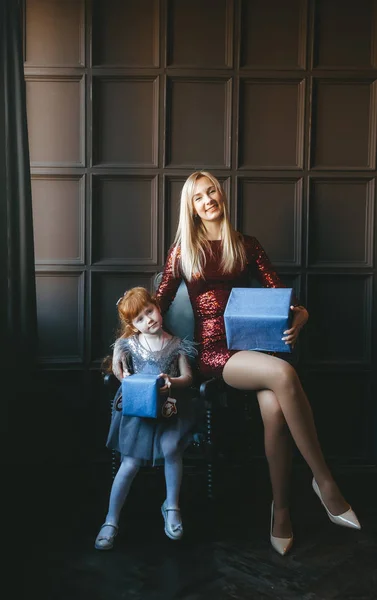 Feliz madre y su hija con cajas de regalo sentadas en sillones — Foto de Stock