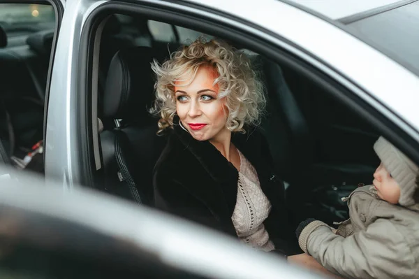 Smiling mother with happy son look aside while sitting near with car driver seat. — 스톡 사진