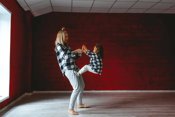 Giovane donna e la sua affascinante figlioletta facendo yoga acroyoga insieme studio sfondo — Foto Stock