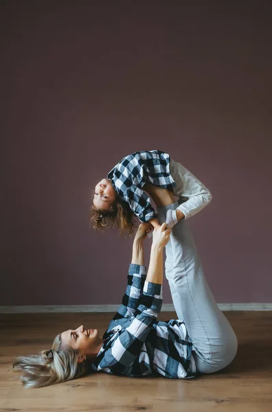 La bambina fa un esercizio acrobatico con sua madre . — Foto Stock