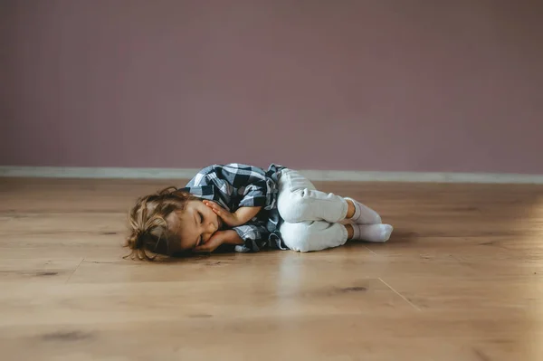 Funny portrait of lying sleep little girl on a floor indoors — Stock Photo, Image