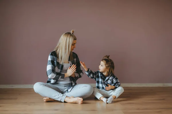 Madre con el niño practicando yoga en una pose de loto y se comunican. Retrato horizontal — Foto de Stock