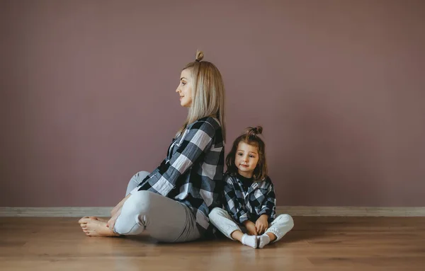 Mutter mit Kind praktiziert Yoga in Lotus-Pose. Seitenansicht — Stockfoto