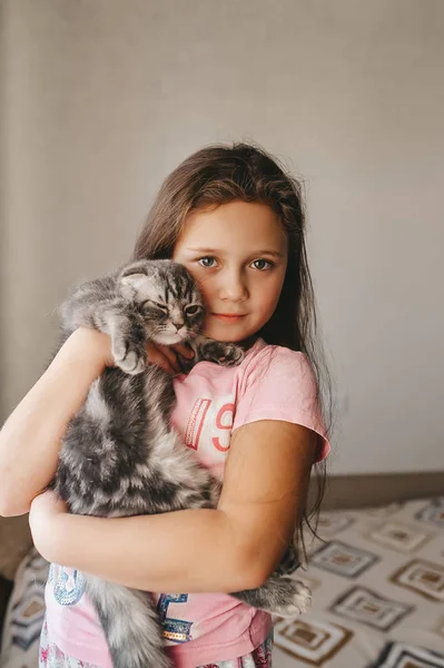 Schönes Kind mit lustigem Kätzchen spielt zu Hause. — Stockfoto