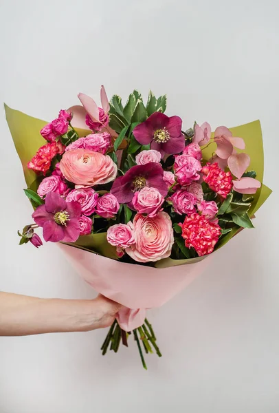 Florista segurando um buquê colorido de flores em sua mão . — Fotografia de Stock