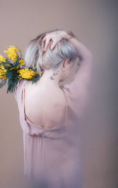 Peri masalındaki gizemli kız sisli arka planda bir buket mimoza çiçeğiyle. Arka plan.