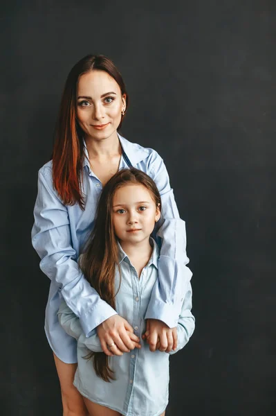 青いシャツを着た母と娘 スタジオ ポートレート 黒を背景に — ストック写真