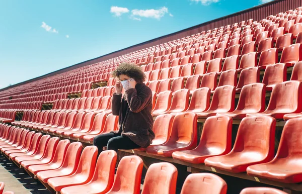 Kobieta Masce Chirurgicznej Siedząca Pustym Stadionie Podczas Epidemii Covid Kręcone — Zdjęcie stockowe