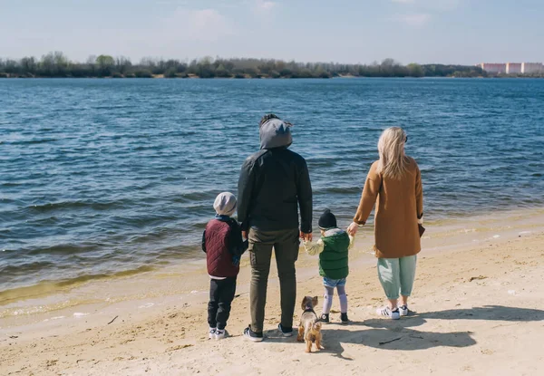 家族の川の岸に立って遠くを見ること 幸せな家族は自然にリラックスします バックビュー — ストック写真