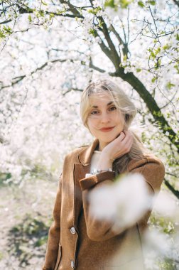 Çiçek açan elma bahçesindeki genç ve güzel kadın. Yakın plan portre