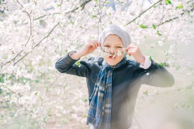 Bahar elma bahçesinde bıyıklı küçük bir çocuk. Takma bıyık. Yatay portre