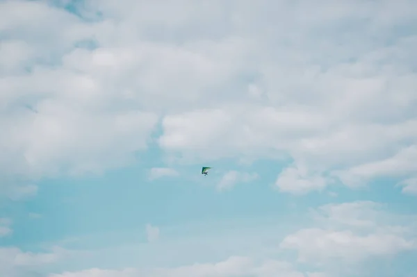 Motor hang glider against the cloudy blue sky