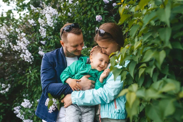 Pai Abraça Mãe Com Pequeno Filho Jardim Florido Retrato Close — Fotografia de Stock