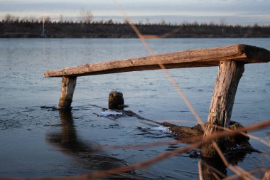 Buz nehrindeki ahşap bank.