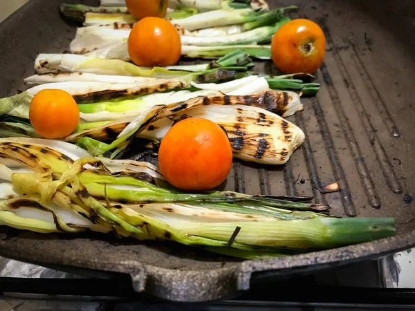 Cooking delicious fresh grilled spring onions with cherry tomato — 스톡 사진