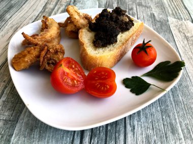 Kızarmış ekmek ve kızarmış dokunaçlarla pişirilmiş ahtapot ciğeri.