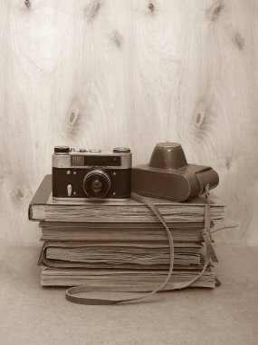 Vintage eski film fotoğraf-fotoğraf makinesi ile deri çanta ahşap arka plan, sepya