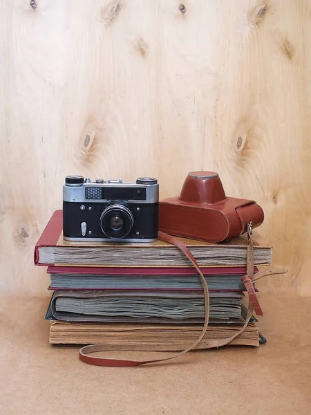 Vintage filme antigo foto-câmera com caixa de couro em fundo de madeira — Fotografia de Stock