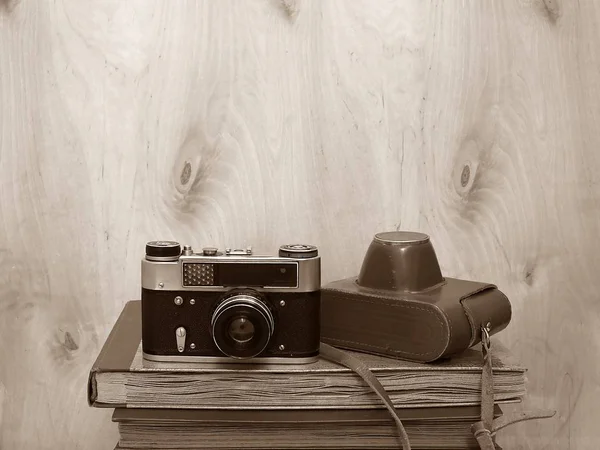 Vintage old film photo-camera and photo-albums on wooden background, sepia — Stock Photo, Image
