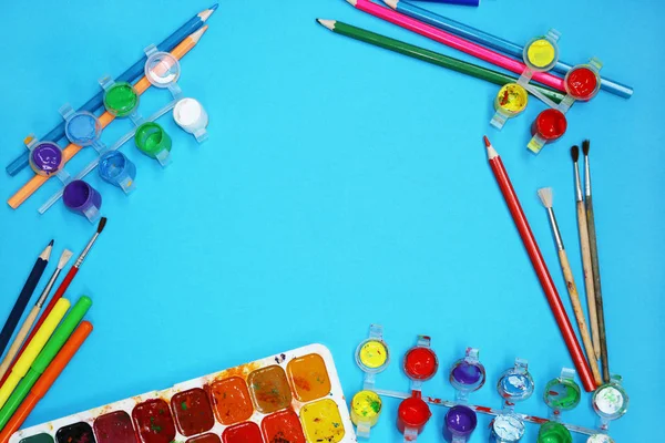 Tintas e pincéis aquarela no fundo azul — Fotografia de Stock