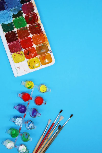 Watercolor Paints And Brushes on blue background — Stock Photo, Image