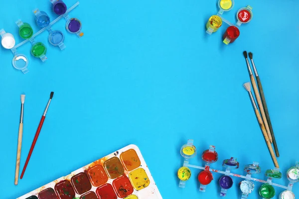 Pitture ad acquerello e pennelli su sfondo blu — Foto Stock