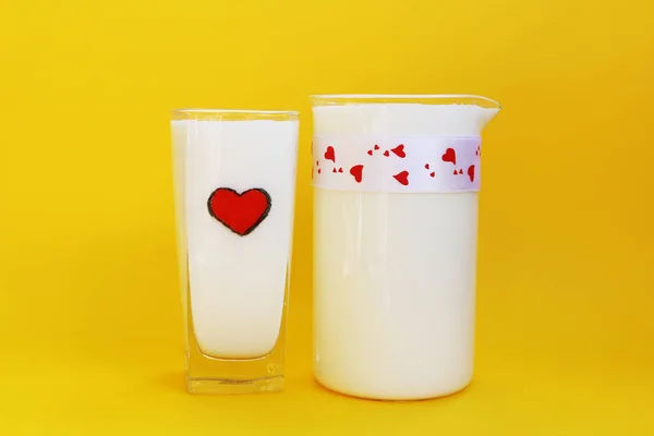 Bir sürahi ve bardak süt sarı arka plan, süt kavramı üzerinde — Stok fotoğraf