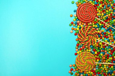  Renkli tatlılar ve mavi arka plan üzerinde lolipop